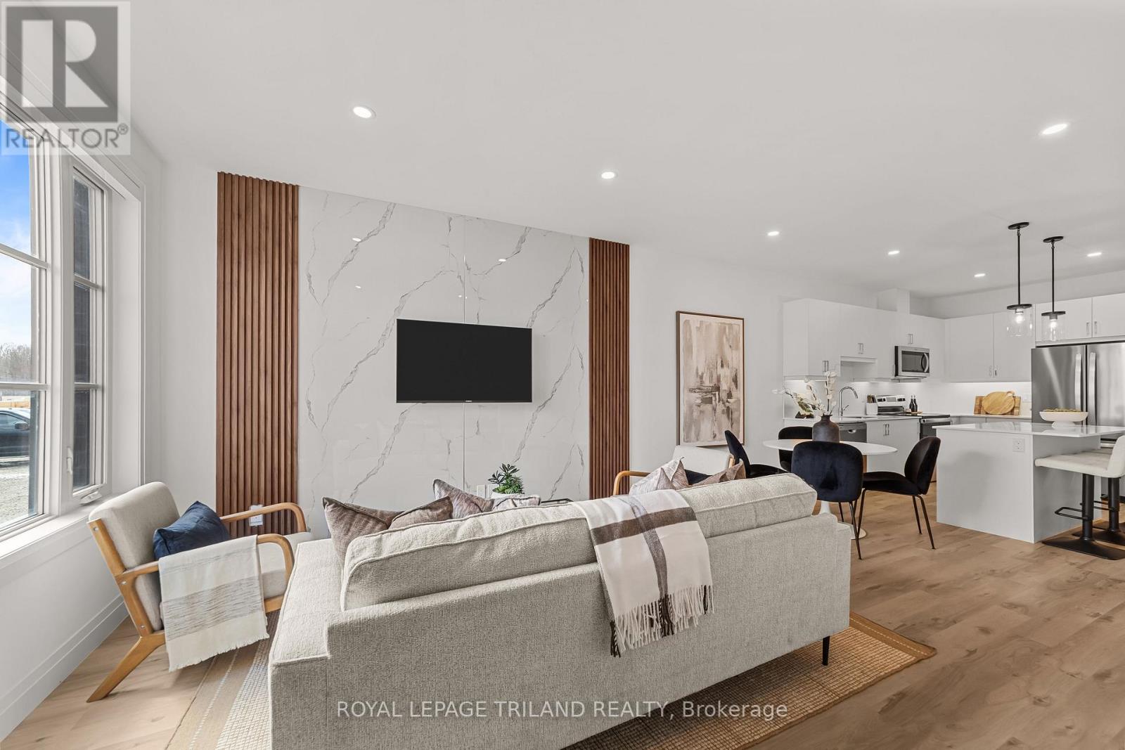 A modern living room with a grey sofa and a television on the wall.