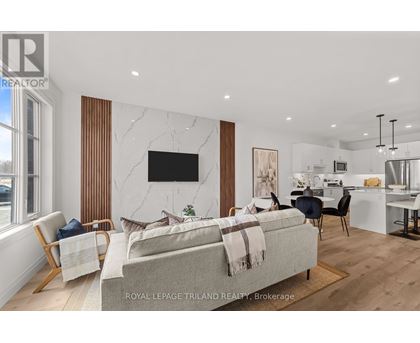 A modern living room with a grey sofa and a television on the wall.