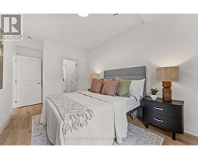 A bedroom with a bed, nightstand, and lamp.