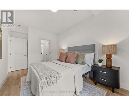 A bedroom with a bed, nightstand, and lamp.