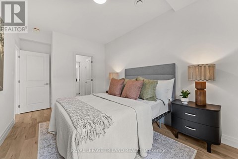 A bedroom with a bed, nightstand, and lamp.