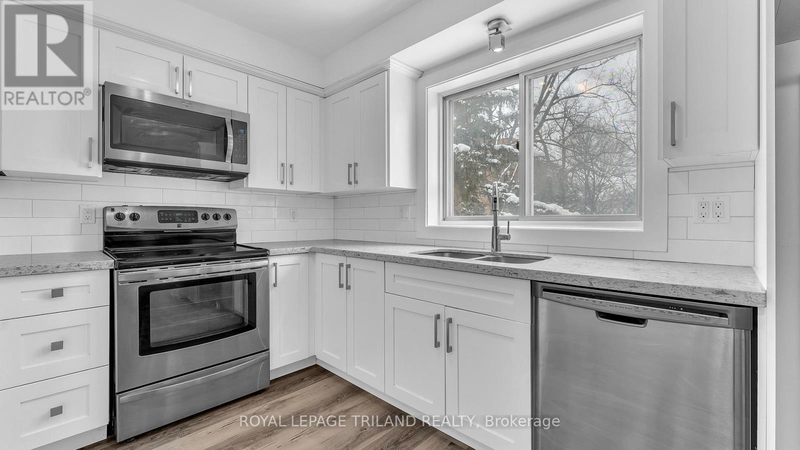 A kitchen with white cabinets and a stainless steel oven.