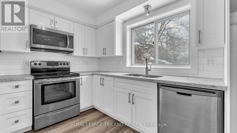 A kitchen with white cabinets and a stainless steel oven.