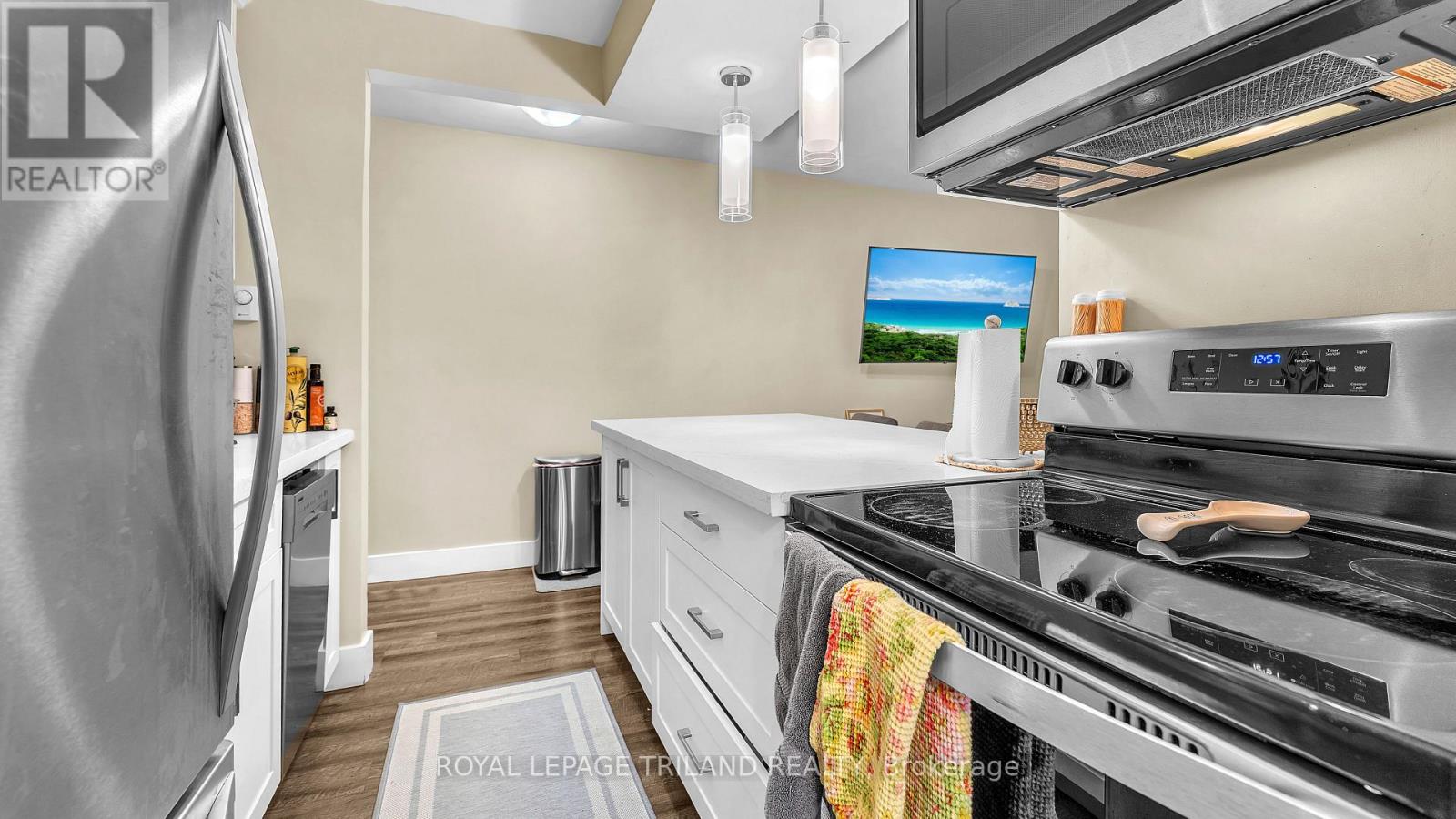 A modern kitchen with a stainless steel refrigerator and a stove top oven.