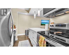 A modern kitchen with a stainless steel refrigerator and a stove top oven.