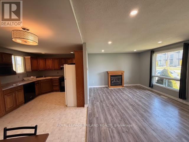 A spacious living room with a fireplace and a dining area with a table and chairs.