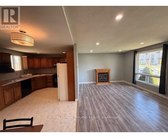 A spacious living room with a fireplace and a dining area with a table and chairs.