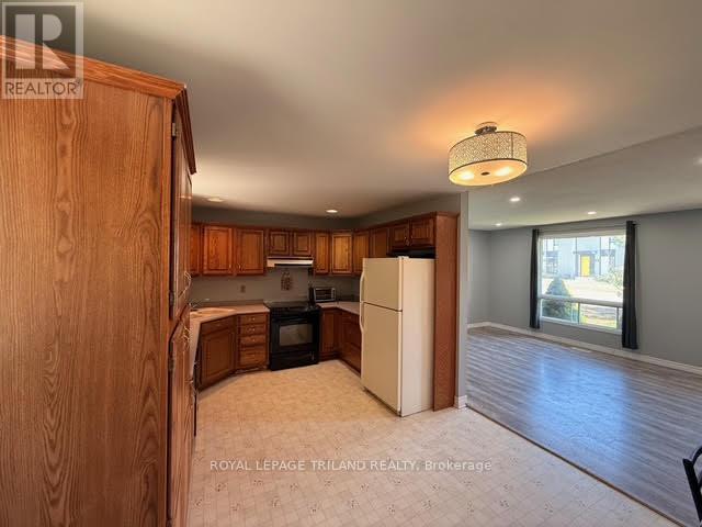 A kitchen with wooden cabinets and a white refrigerator.