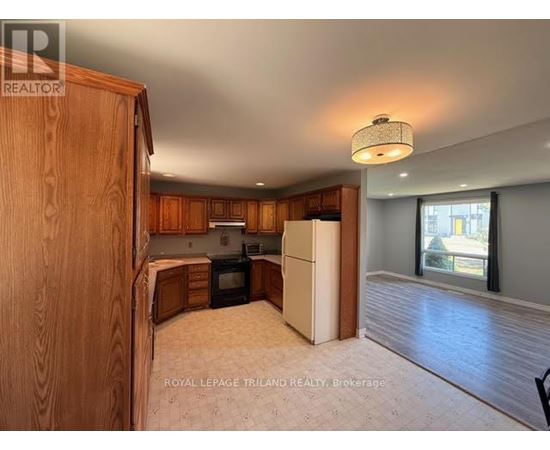 A kitchen with wooden cabinets and a white refrigerator.