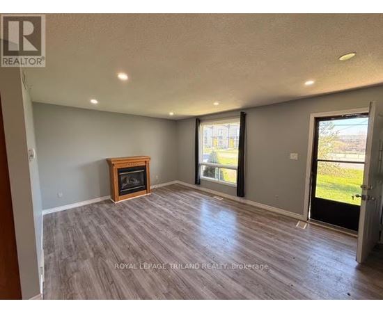 A spacious room with a fireplace and sliding glass doors.