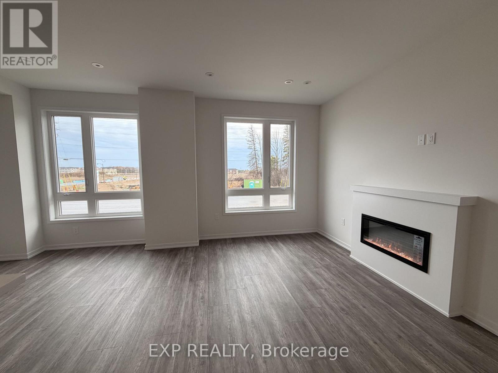 A spacious room with a fireplace and large windows.