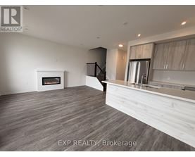 A spacious room with a fireplace and a staircase.