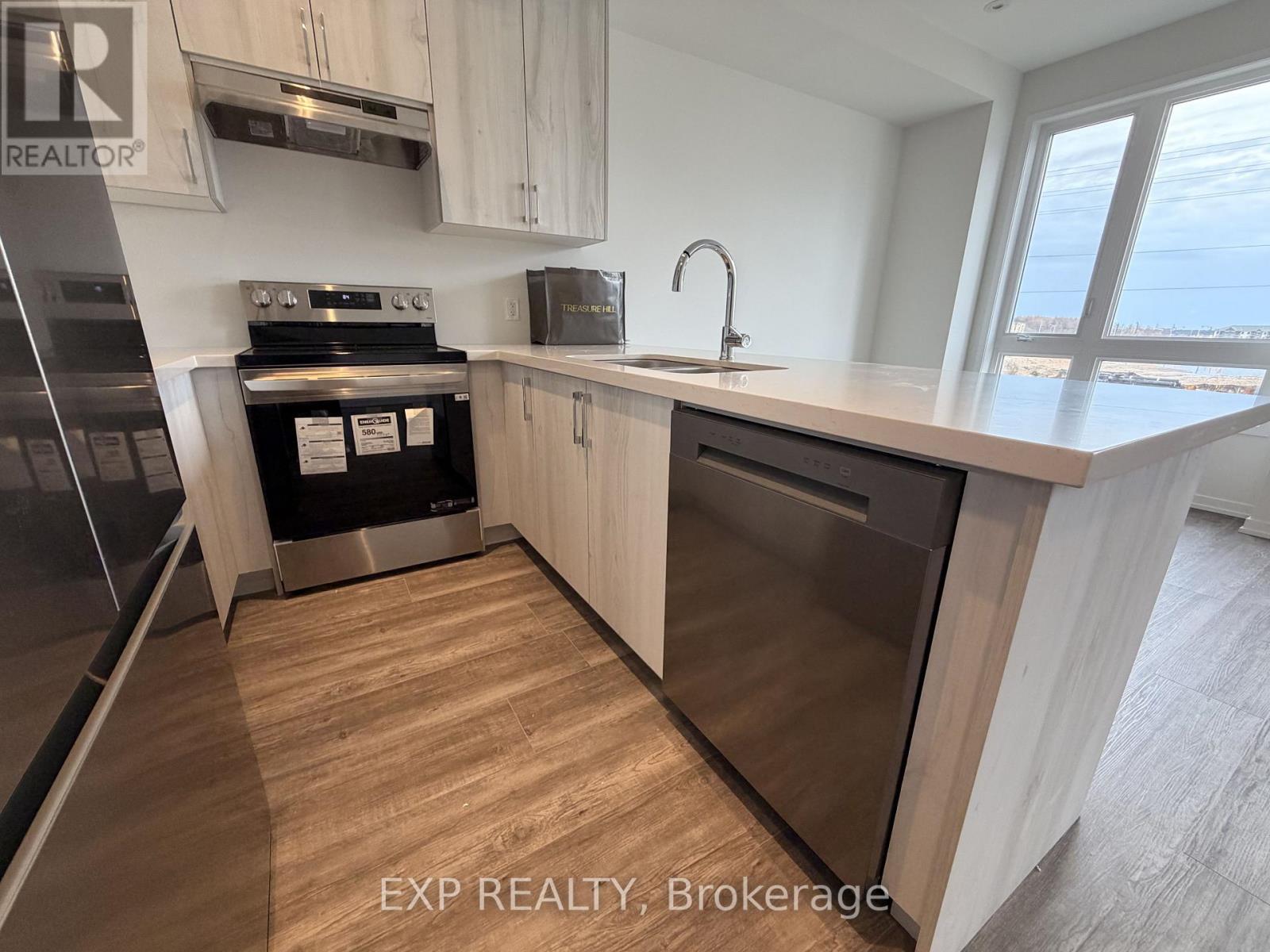 A kitchen with wooden floors and a stainless steel dishwasher.