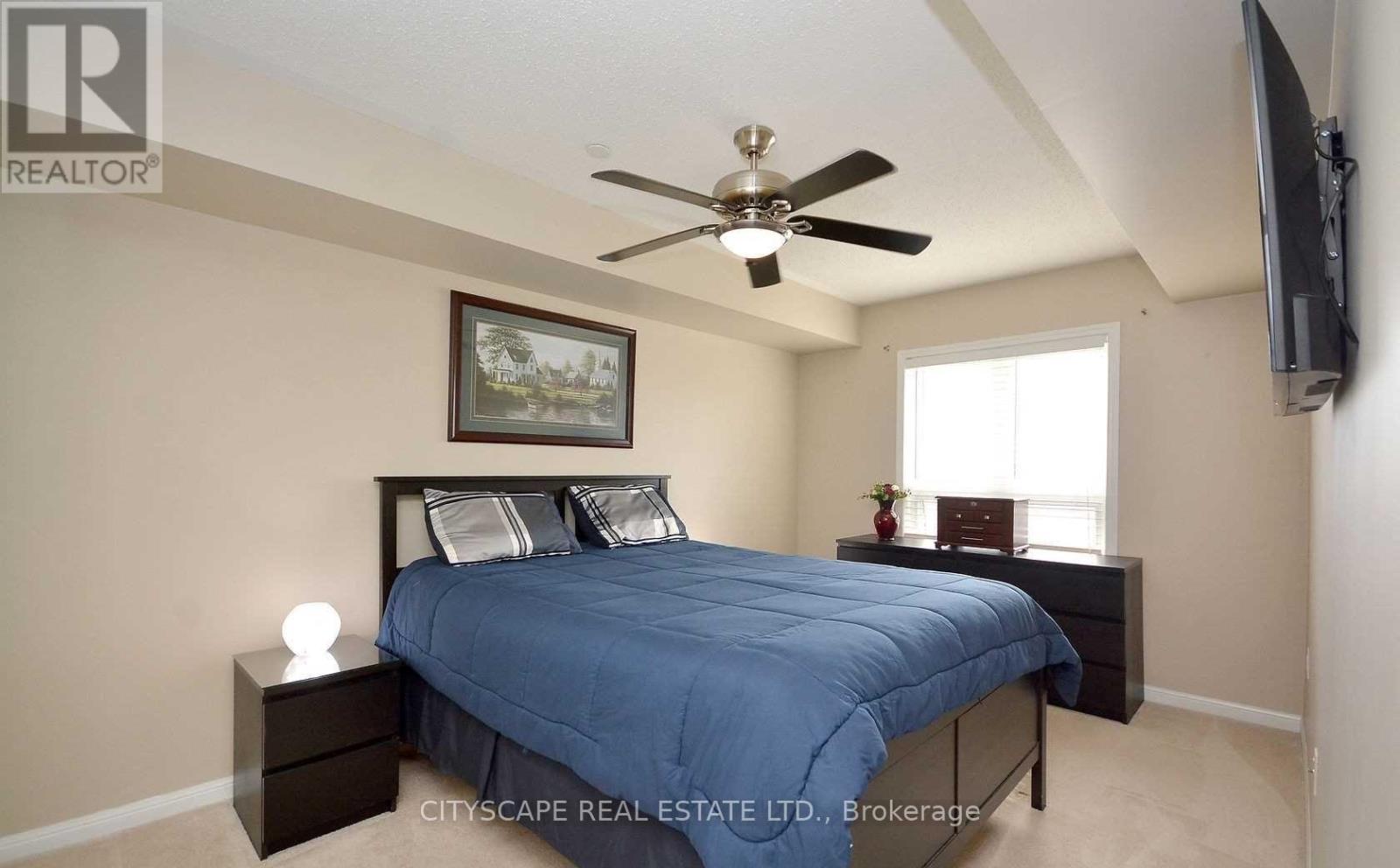 A bedroom with a bed, nightstand, and a ceiling fan.