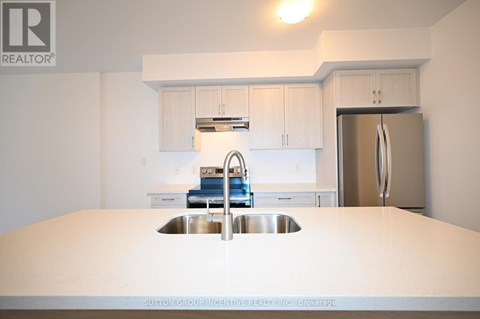 A kitchen with a sink and a refrigerator.