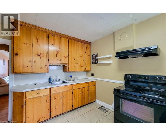 A kitchen with wooden cabinets and a black stove top oven.