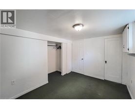 A white bedroom with a doorway leading to another room.