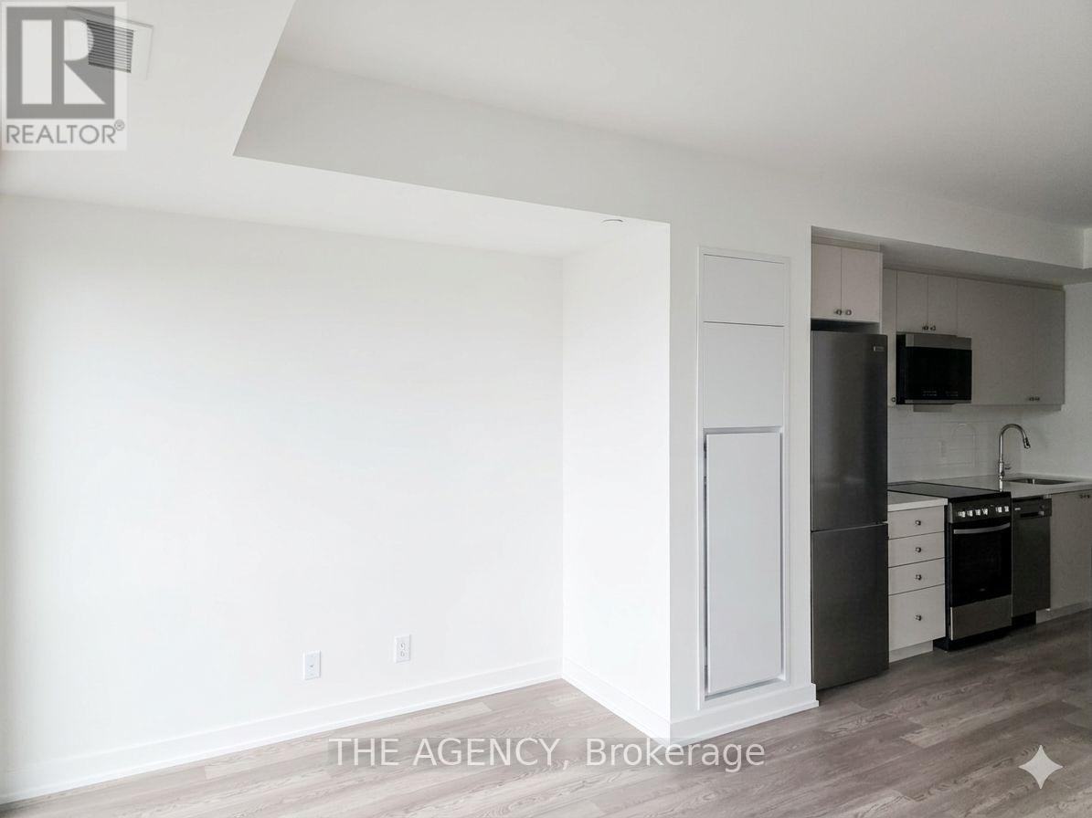 A white kitchen with a refrigerator, oven, and sink.