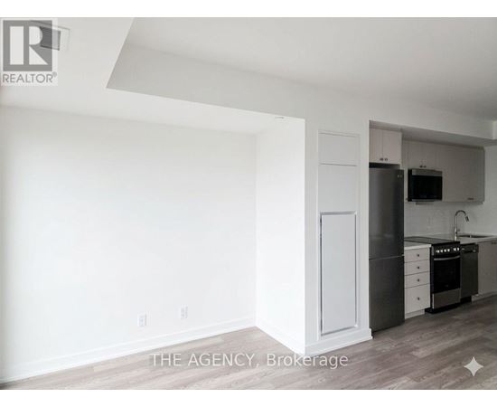 A white kitchen with a refrigerator, oven, and sink.
