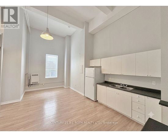 A well-lit, spacious kitchen with white cabinets and a black countertop.
