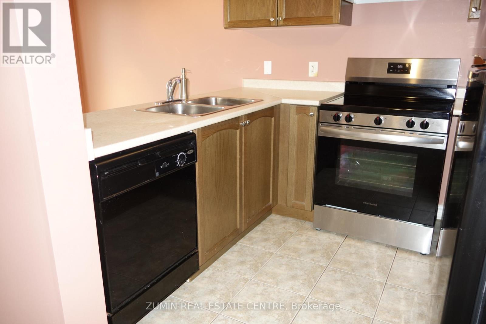 A kitchen with a black oven and a stainless steel range hood.