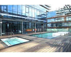 A pool area with a hot tub and a glass wall.