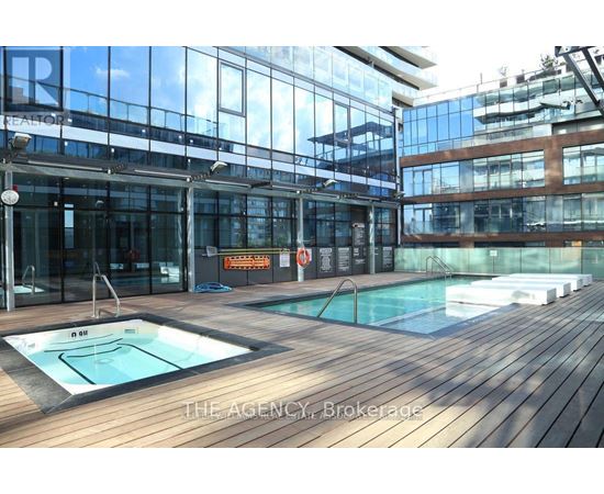 A pool area with a hot tub and a glass wall.