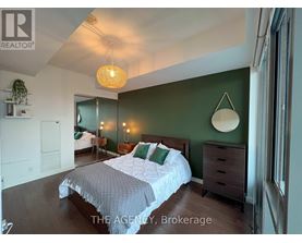 A bedroom with a bed, dresser, and mirror.