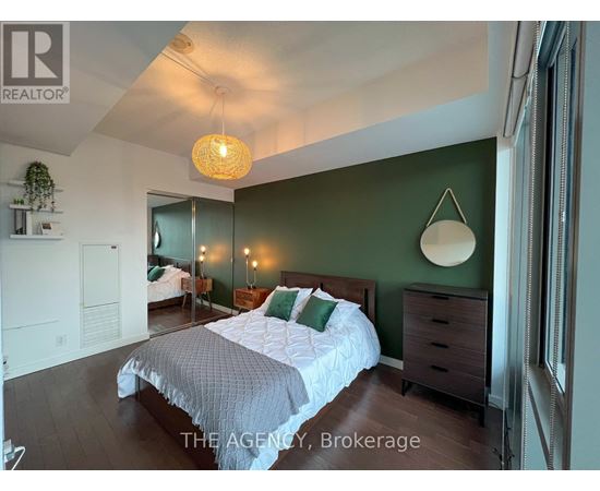 A bedroom with a bed, dresser, and mirror.