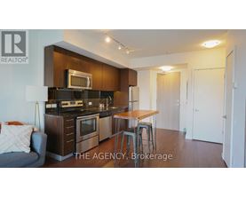 A modern kitchen with dark wood cabinets and stainless steel appliances.