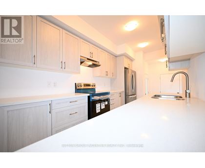 A kitchen with white countertops and wooden cabinets.