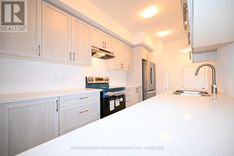 A kitchen with white countertops and wooden cabinets.