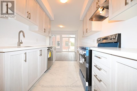 A kitchen with white cabinets and a black stove top oven.