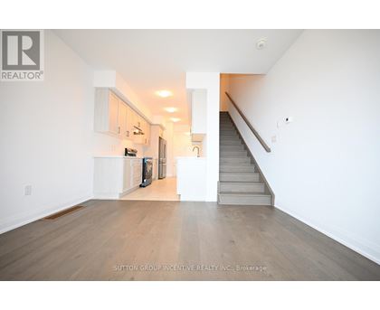 A spacious room with a staircase leading to the upper floor.