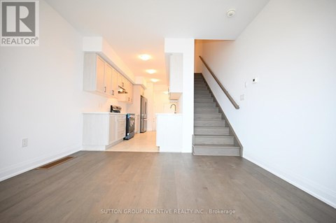 A spacious room with a staircase leading to the upper floor.