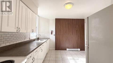 A kitchen with white cabinets and a brown countertop.
