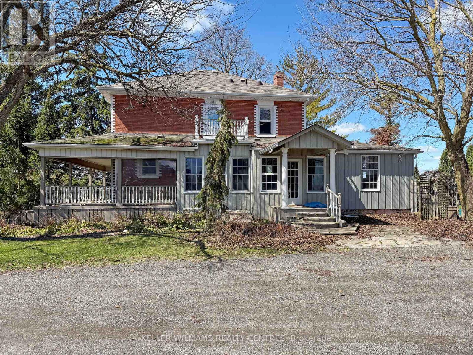 A red brick house with a porch and a white door.