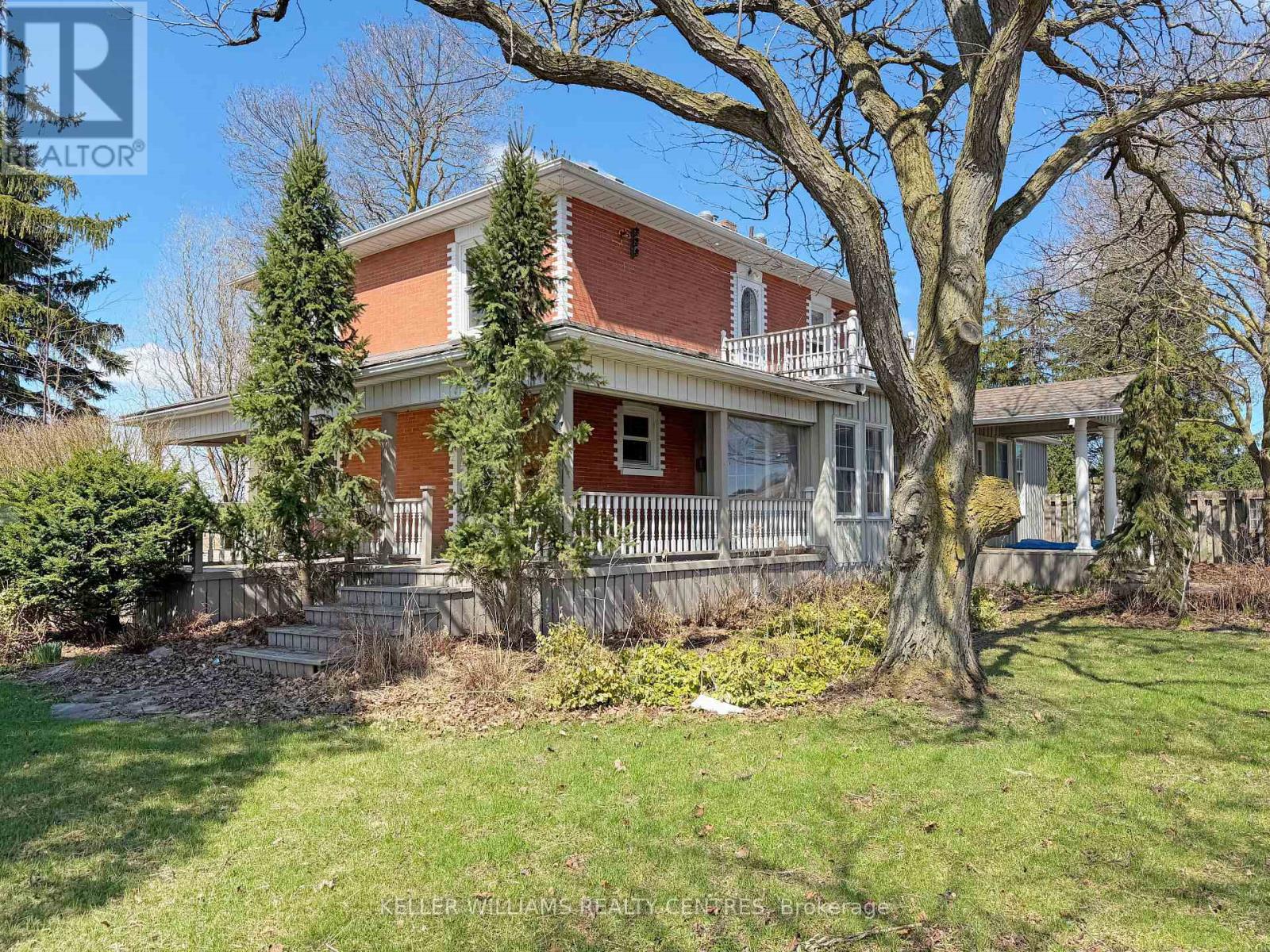 A house with a red brick exterior and a white porch.