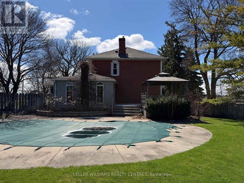 A red brick house with a pool in the backyard.