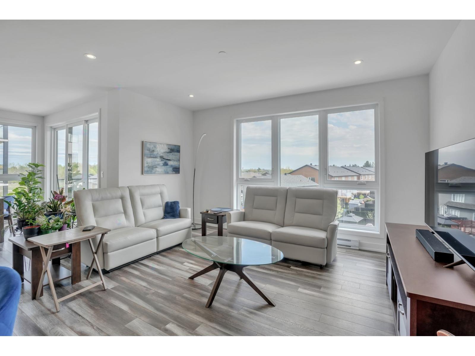 A living room with a white couch and a glass table.
