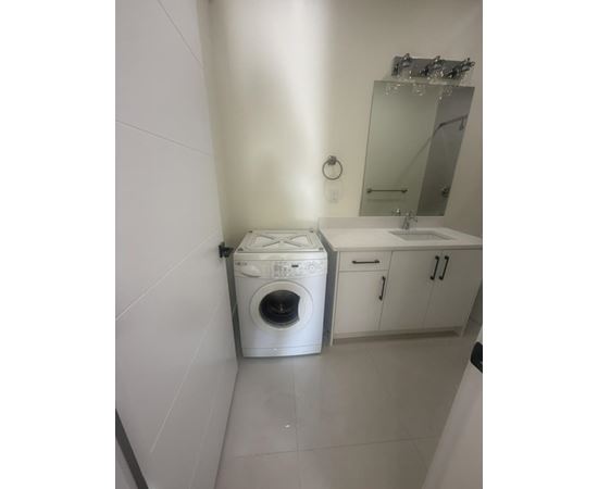 A white washing machine is in a small bathroom.