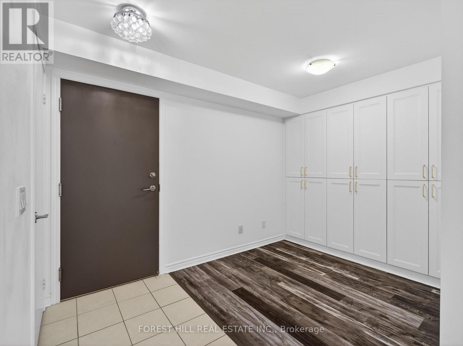 A room with a brown door and white walls.