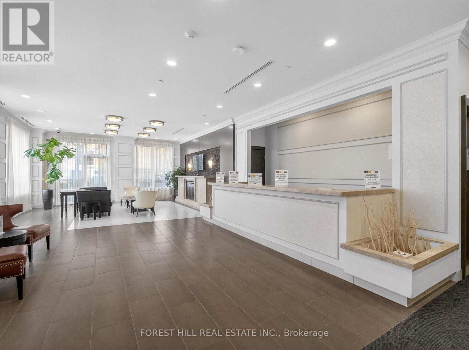 A spacious living room with a piano and a reception desk.