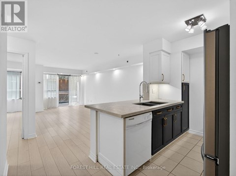 A kitchen with white cabinets and a black refrigerator.