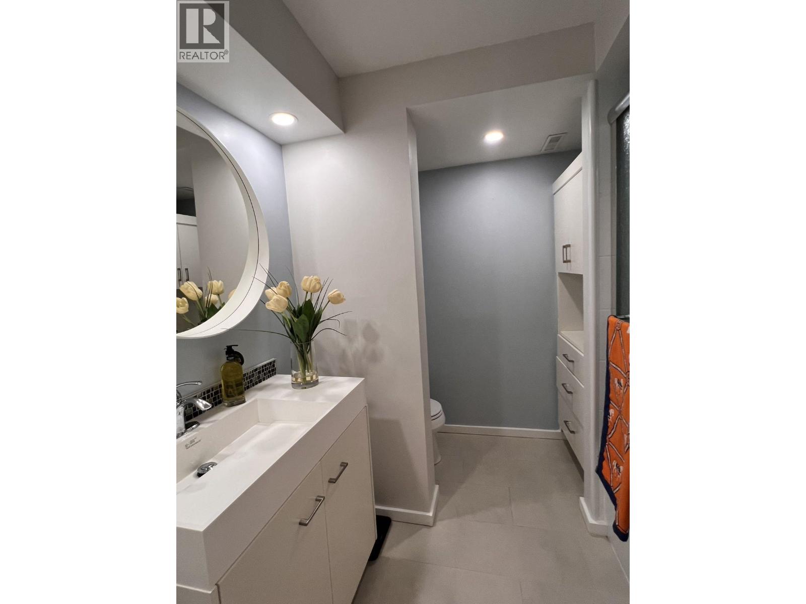 A bathroom with a sink, mirror, and towel rack.