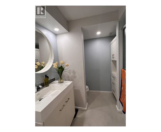A bathroom with a sink, mirror, and towel rack.