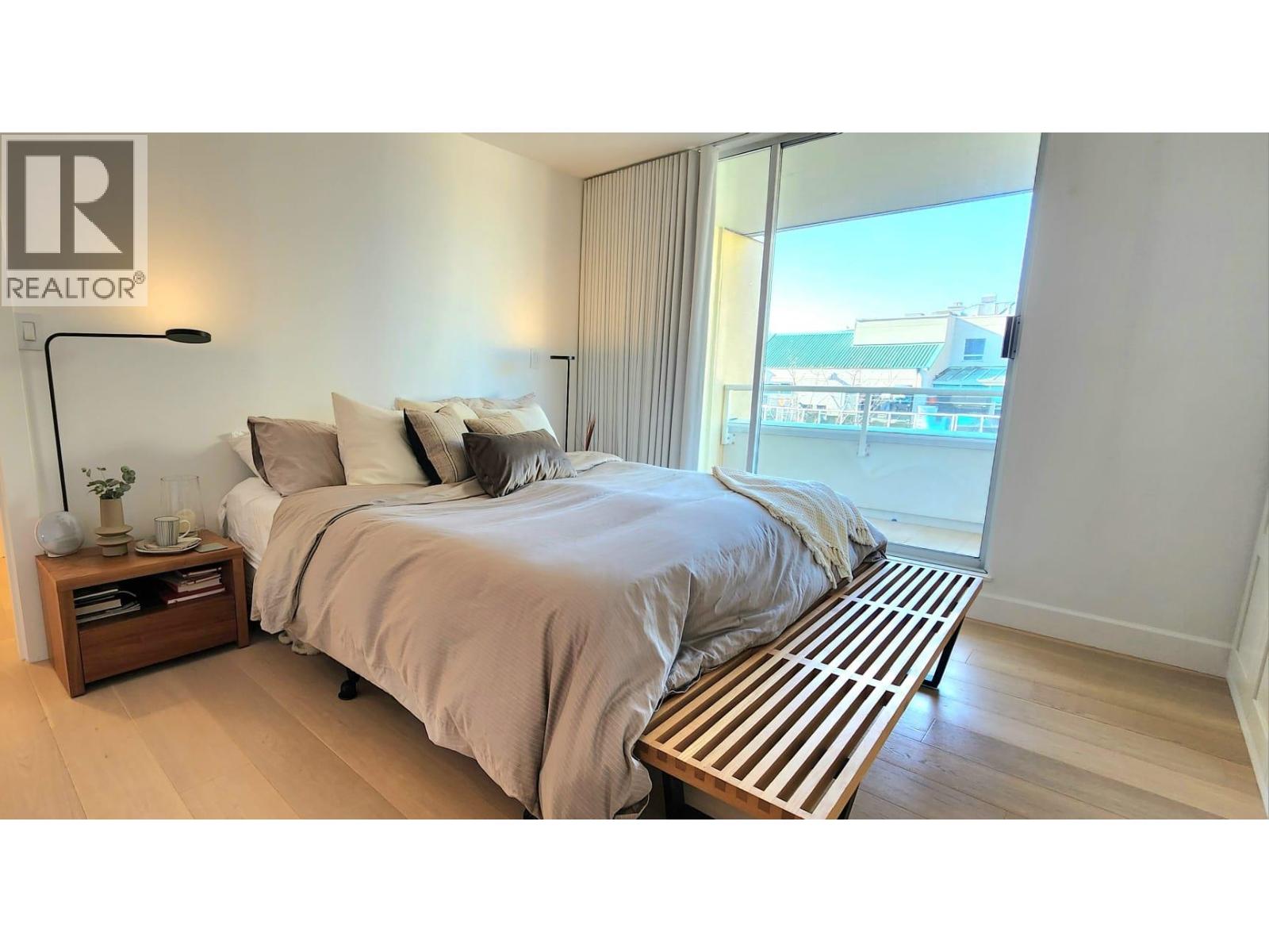 A bedroom with a large bed and a wooden bench in front of it.