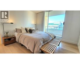 A bedroom with a large bed and a wooden bench in front of it.