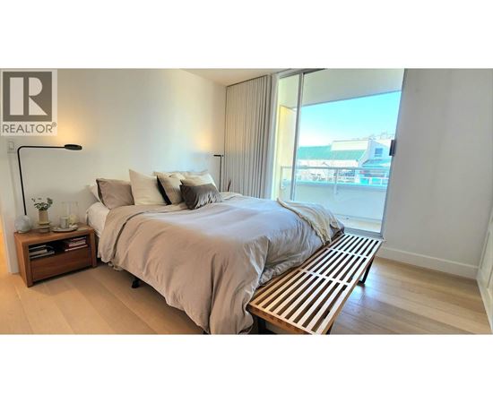 A bedroom with a large bed and a wooden bench in front of it.