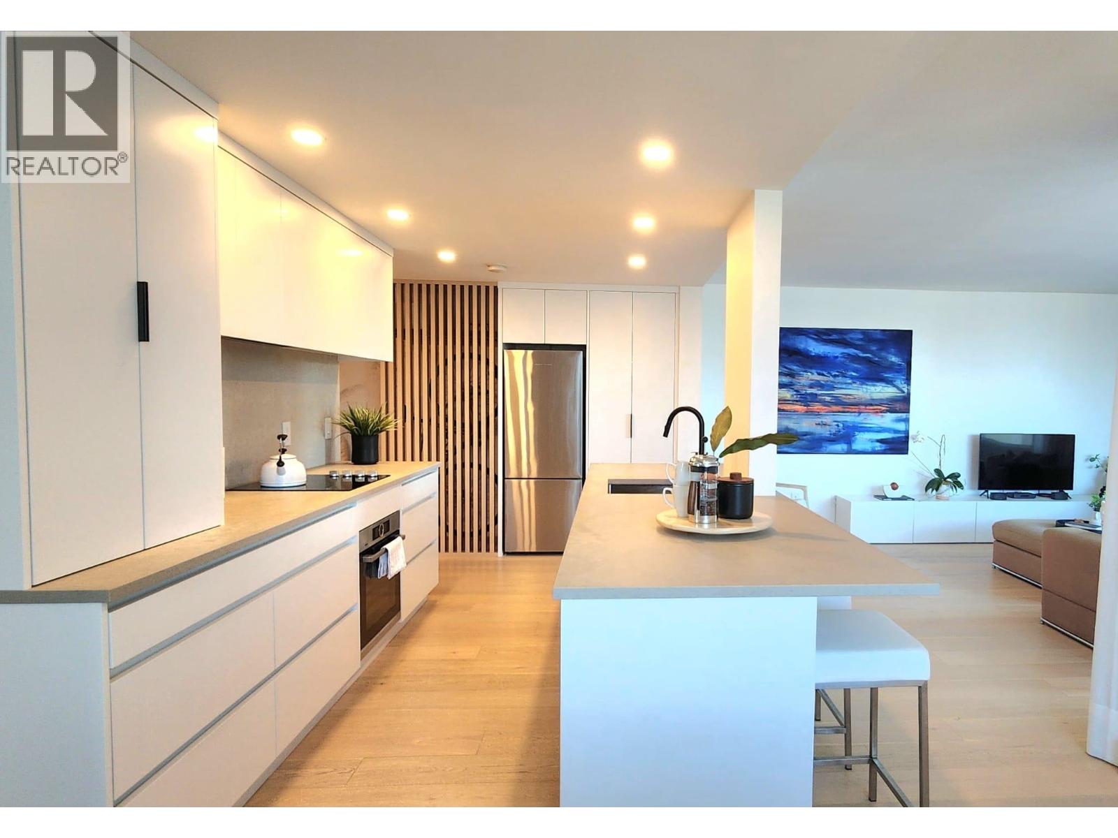 A modern kitchen with white cabinets and a central island.